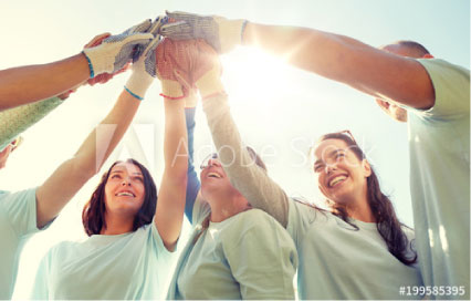 Group of people holding hands in the air smiling