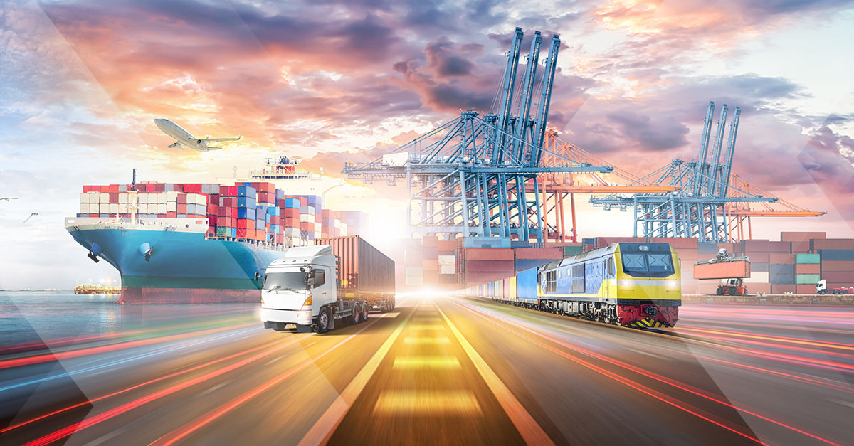 plane flying over a container ship with a truck driving alongside a train 