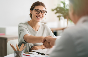 Lady with glasses shaking a mans hand