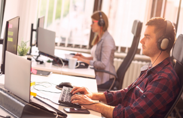 male and female with headsets on working at desks