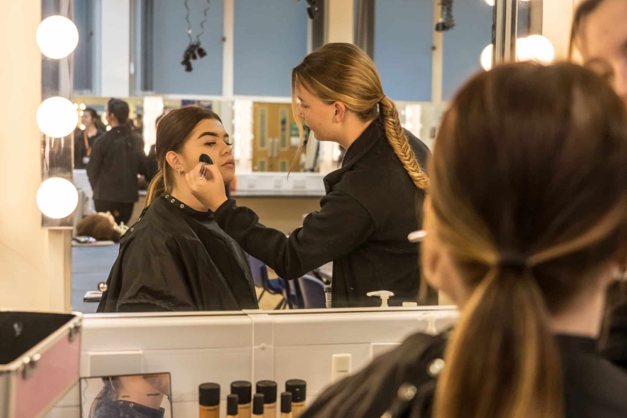 Female make up artist doing makeup on a young lady