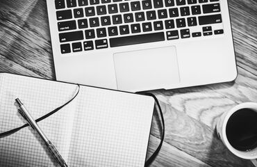 Laptop and a notepad in black and white