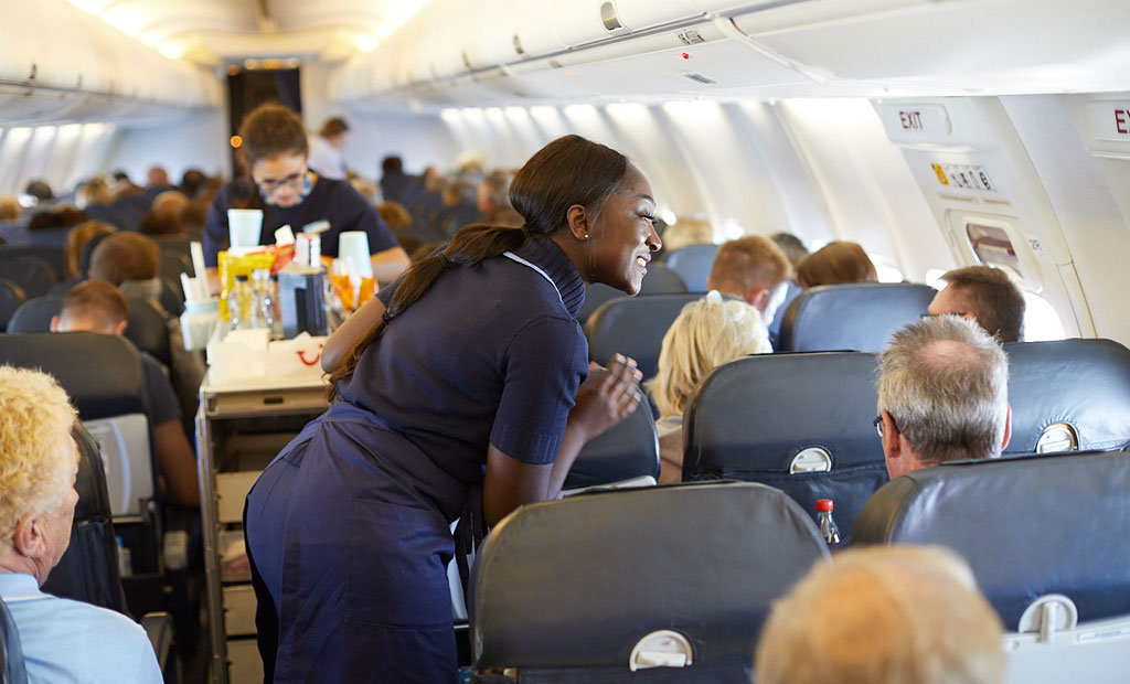 Two cabin crew ladies in the aisle of an aeroplane