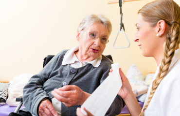 Female medical staff putting a bandage on a elder lady