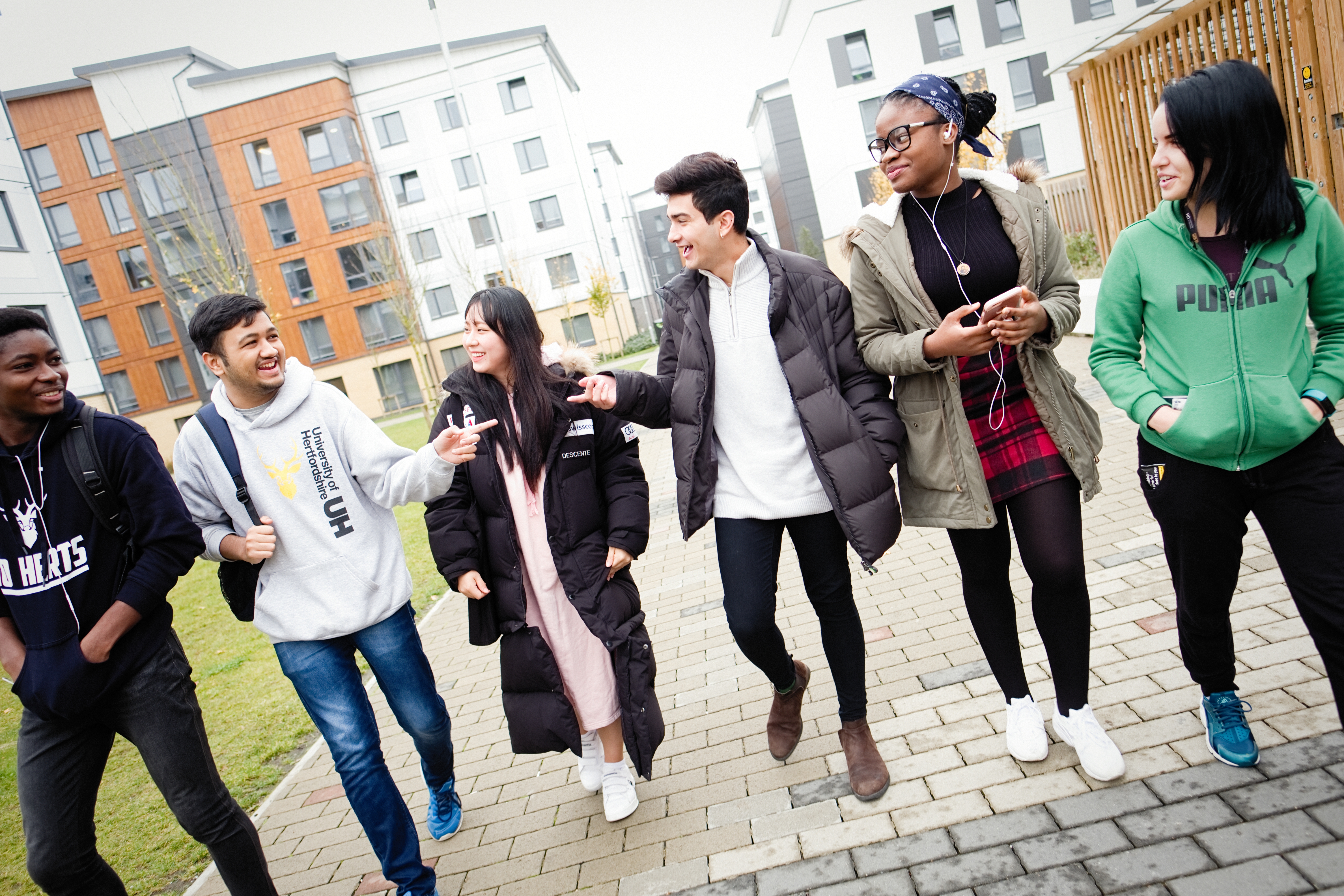 Group of students walking down a path laughing and talking