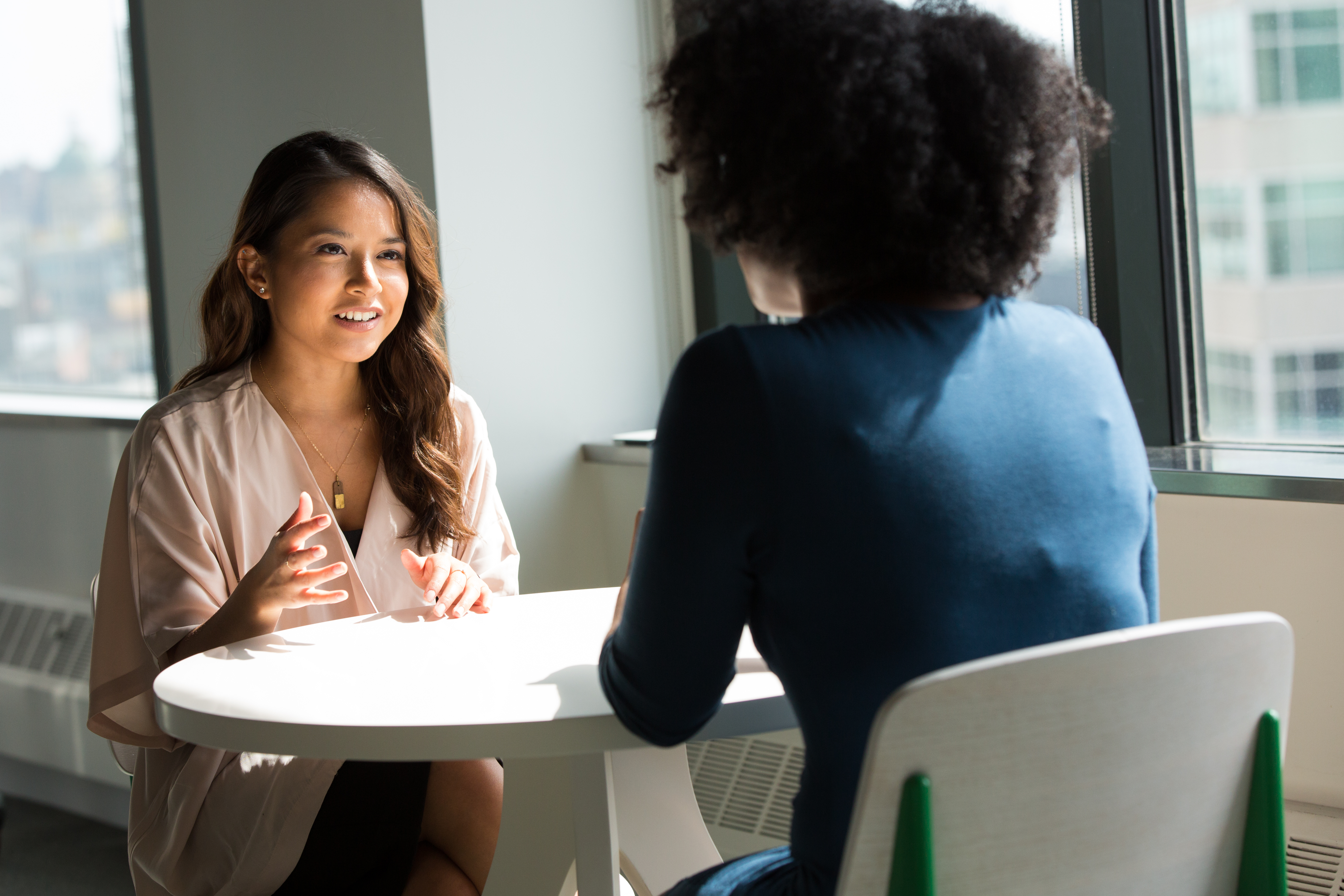 Two ladies sat at a table talking