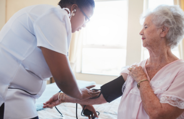 Female medical person taking an elderly ladies blood pressure