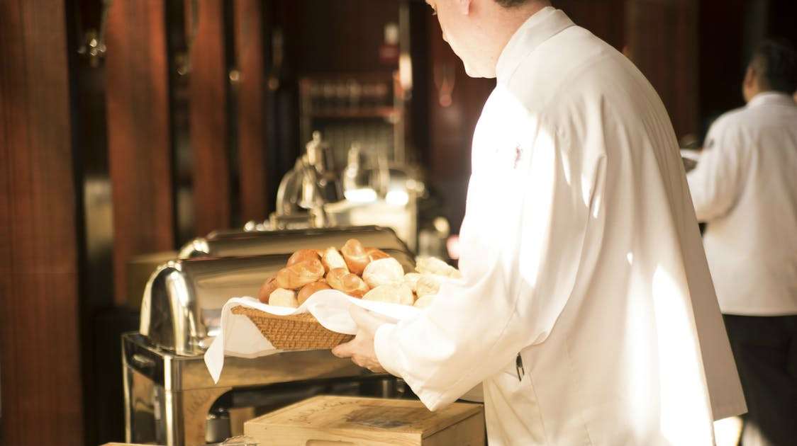 Chef carrying a basket of bread