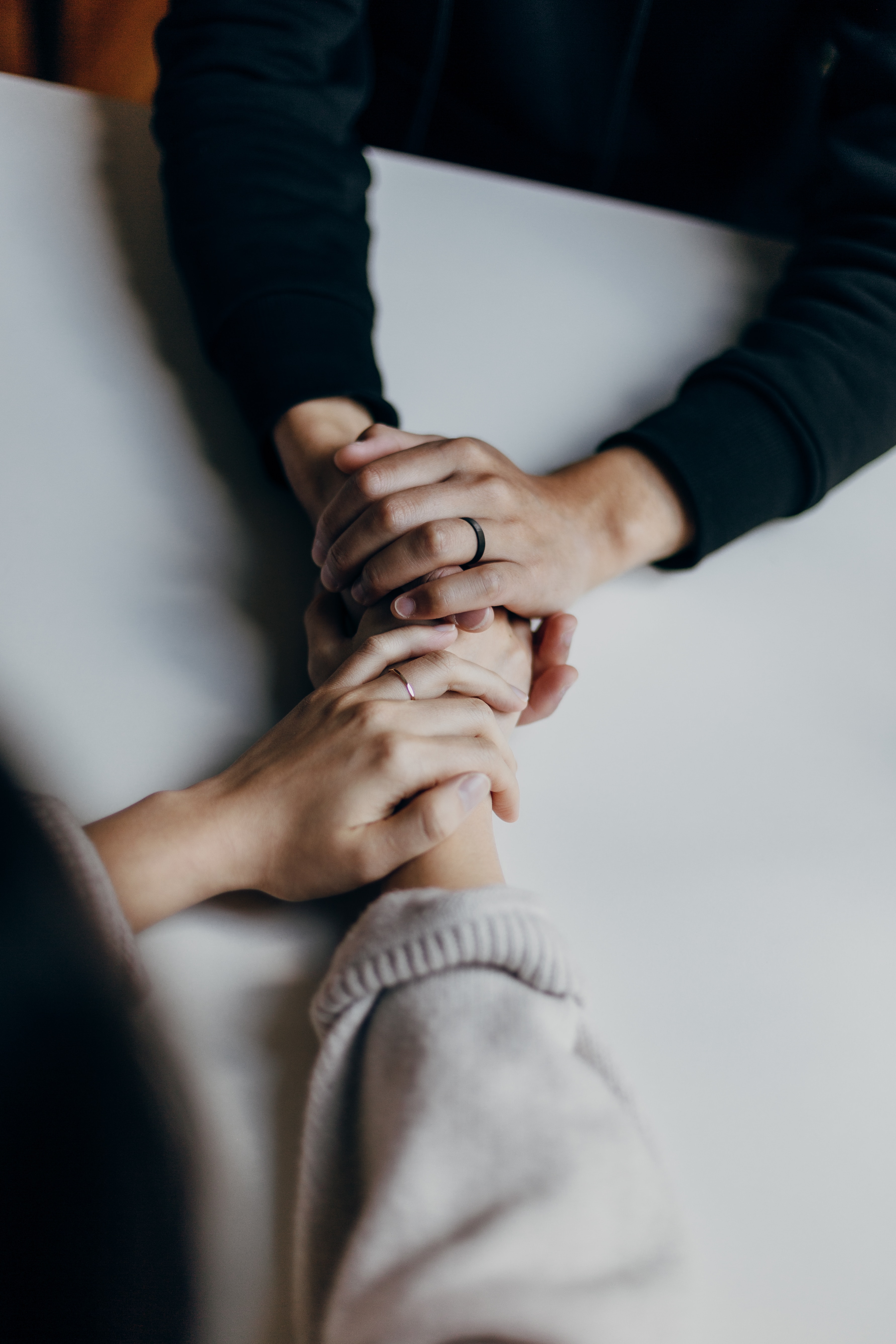 Two people holding hands over a table