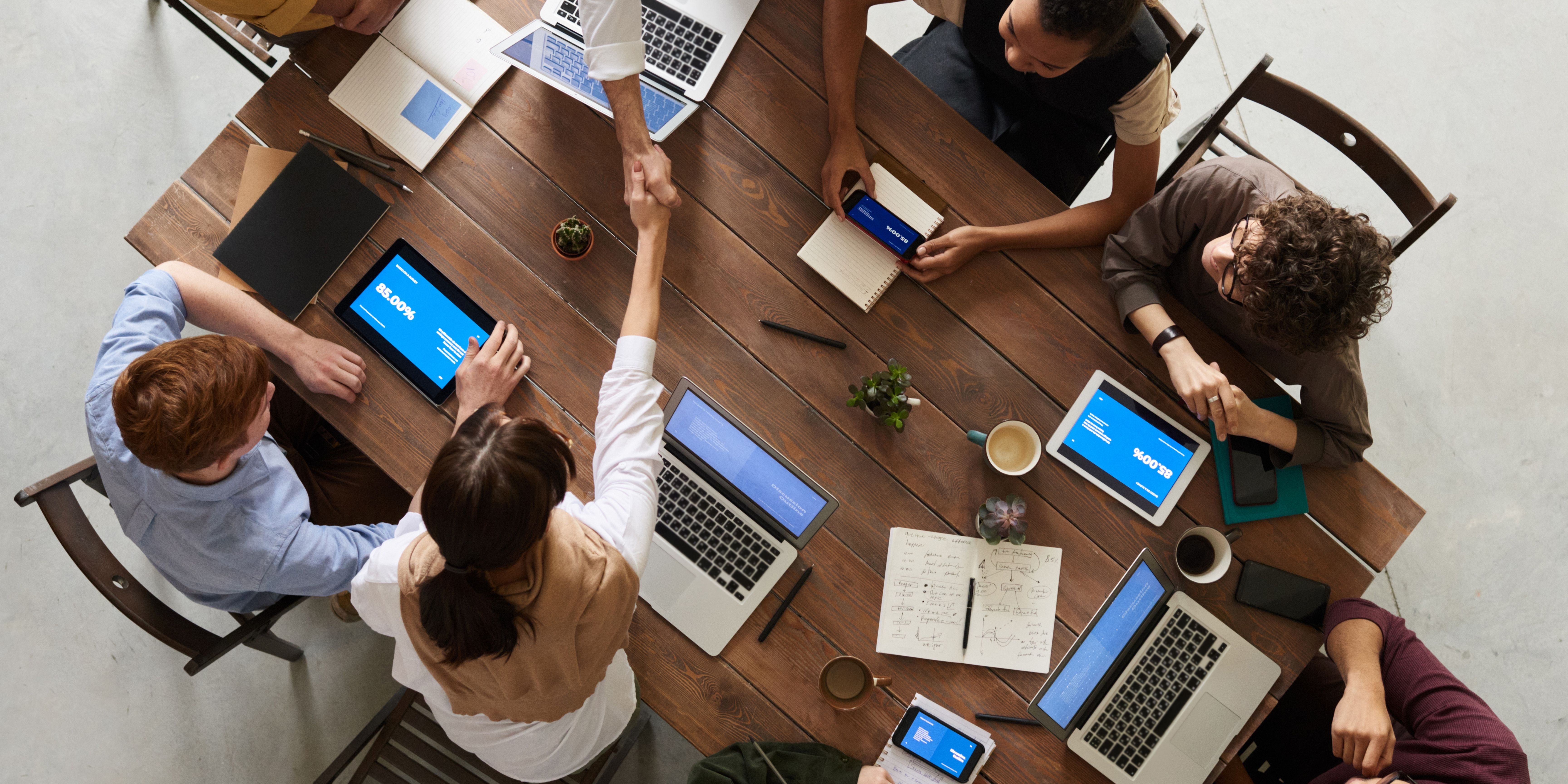 ariel view of people working around a table with laptops