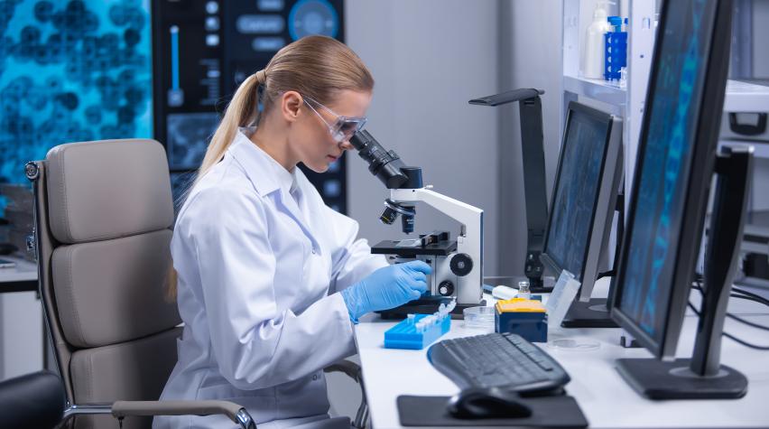 Female scientist looking into a microscope 